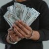 person holding fan of dollar bills