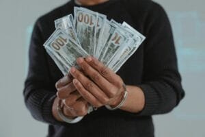 person holding fan of dollar bills