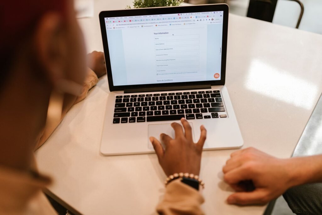 Personne remplissant un formulaire en ligne sur ordinateur portable pour demander une équivalence de diplôme en Belgique